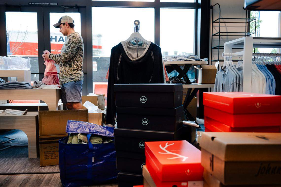 Worth Honeycutt, a part owner of Gentleman’s Corner, helps set up the store’s new location at Rogers West in downtown Cary, N.C., Tuesday, May 28, 2024.