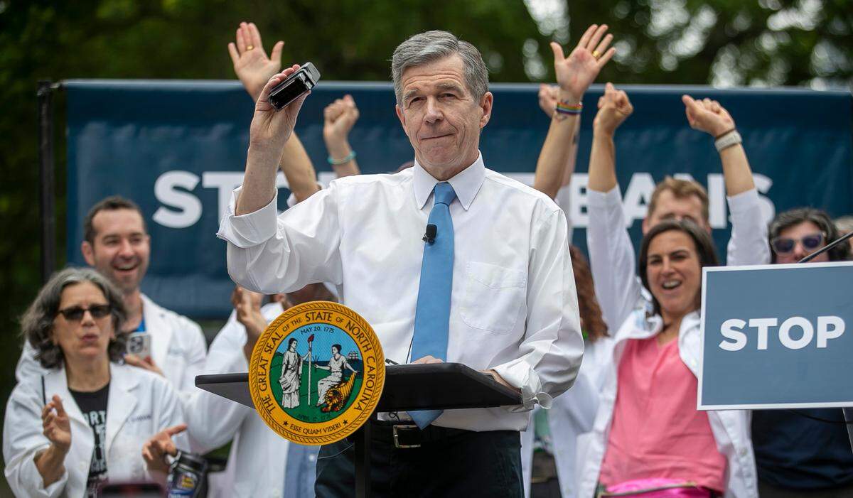 North Carolina Governor Roy Cooper displays his veto stamp after after using it and his signature to veto SB 20, legislation that would restrict abortions in North Carolina, during a public rally on the Bicentennial Mall across the State Capitol on Saturday, May 13, 2023 in Raleigh, N.C.