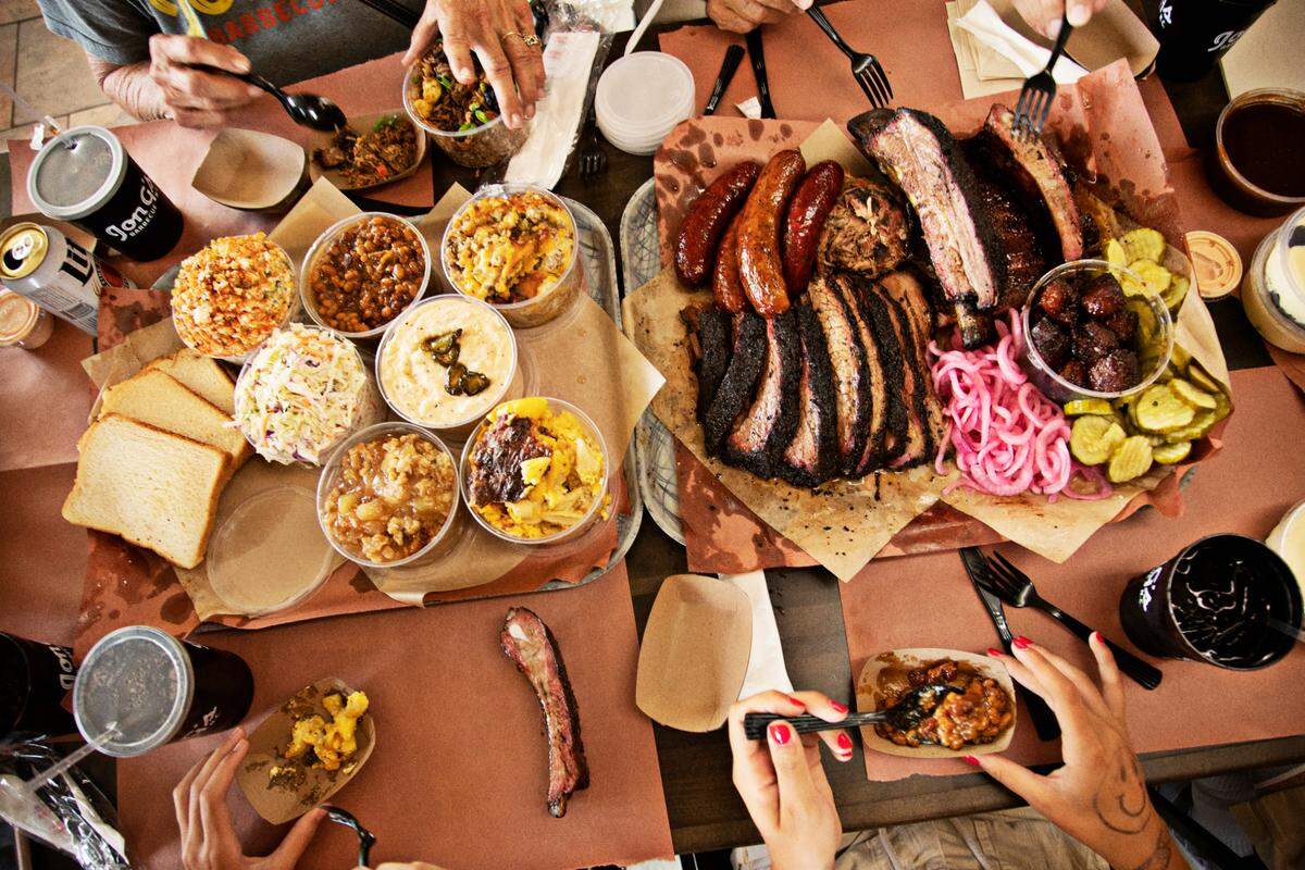 Kelly Kirkman’s family digs into an order that includes ribs, brisket, pulled pork, turkey and house-made sausage links along with a variety of sides including mac & cheese, brown sugar smoked beans, jalapeño cheese grits, cole slaw, and Mexican street corn salad at Jon G’s Barbecue on Saturday, June 22, 2022, in Peachland, NC.
