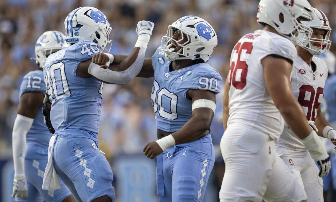 North Carolina linebacker Tyler Thompson (40) celebrates with defensive lineman Xavier Lewis (90) after sacking Stanford quarterback Elijah Brown (2) for an eight yard loss in the first quarter on Saturday, November 8, 2025 at Kenan Stadium in Chapel Hill, N.C.