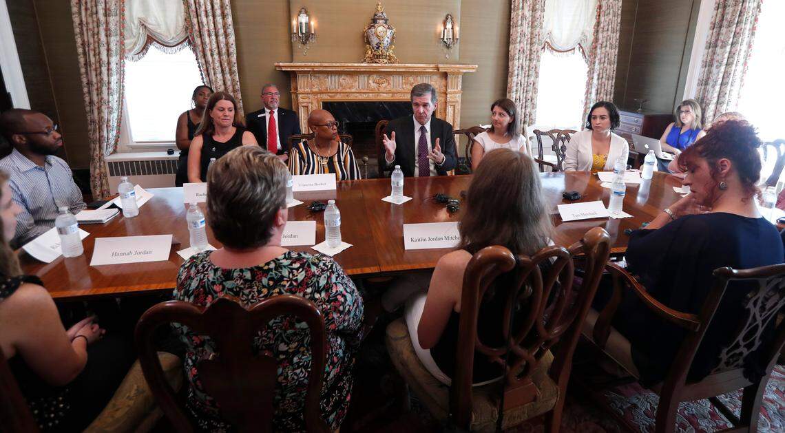 Gov. Roy Cooper talks with North Carolina residents who do not have health insurance during a roundtable at the Andrews-London House in Raleigh, N.C., Wednesday, July 17, 2019.