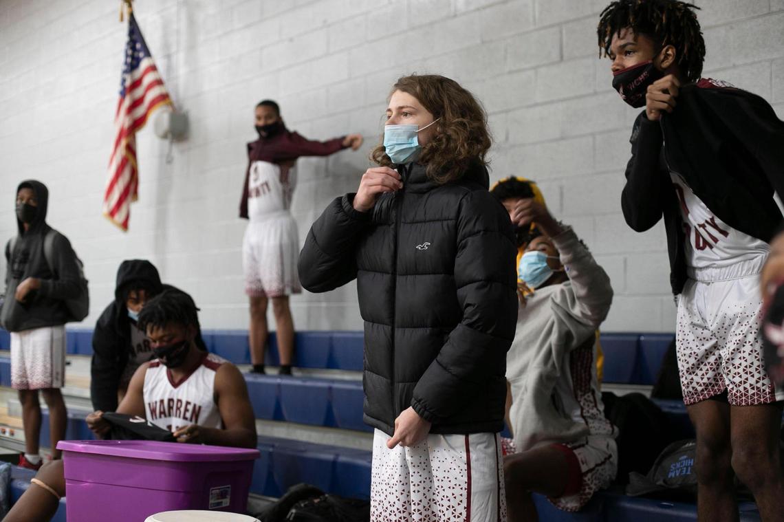 Rocky Carter and his teammates on the Warren County High School basketball team put on their winter coats after changing into their game uniforms to watch the conclusion of the girls game at the John Graham Gym on Friday, January 29, 2021 in Warrenton, N.C. The high school teams are playing their home games at John Graham while their school gym is renovated.