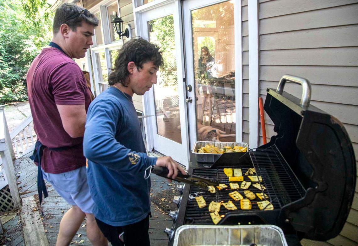 Tom Sullivan, left, and Kevin Gallagher, a N.C. State rising sophomore, prepare a meal Tuesday, July 6, 2021 at the home of Tom and Rachael Sullivan in Raleigh. The Sullivans started offering free food for college students after they went viral on Ticktock and, what started out as Tom’s secret Instagram account to keep track of Rachael’s favorite meals, @mealssheeats, gained more than 70k followers in two months.