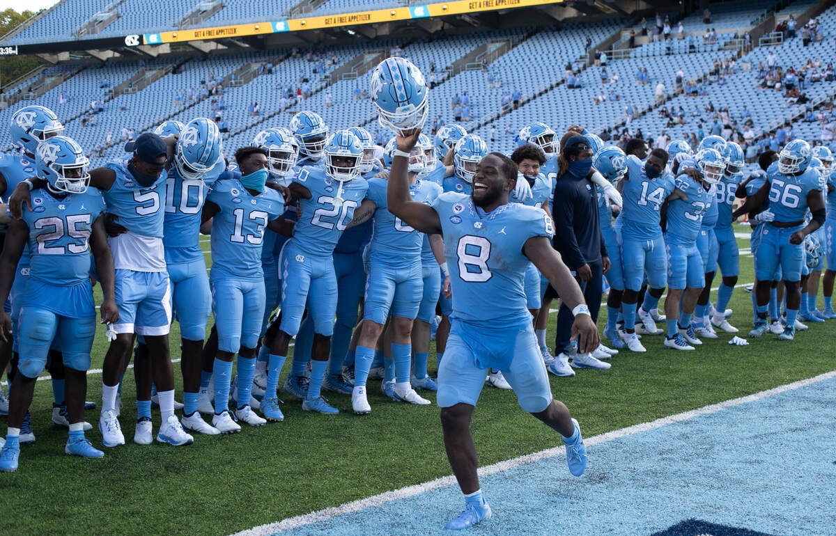 North Carolina’s Michael Carter (8) celebrates with his teammates following the Tar Heels’ 48-21 victory over N.C. State at Kenan Stadium on Saturday, October 24, 2020 in Chapel Hill, N.C. Carter rushed for 106 yards in the Tar Heels’ victory.