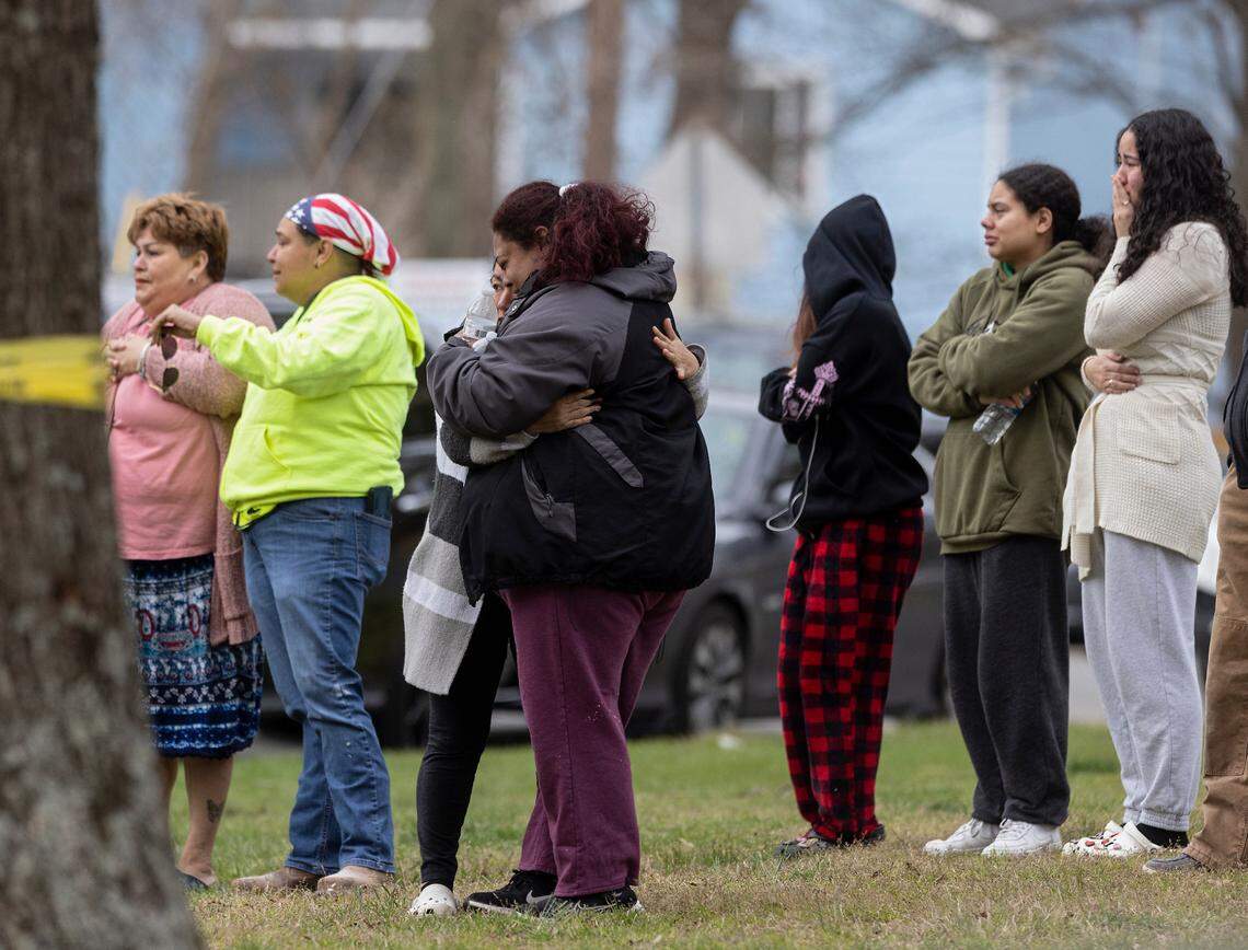People gather near the intersection of Hudson Avenue and North Buchanan Boulevard as law enforcement investigate a homicide on Wednesday, March 22, 2023, in Durham, N.C.