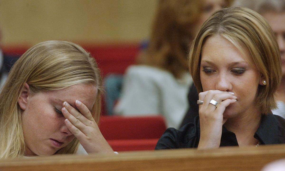 Caitlin Atwater covers her face and her cousin Kim Hunt turns away as an evidence photo of Kathleen Peterson is shown on a projection screen in the courtroom Thursday.