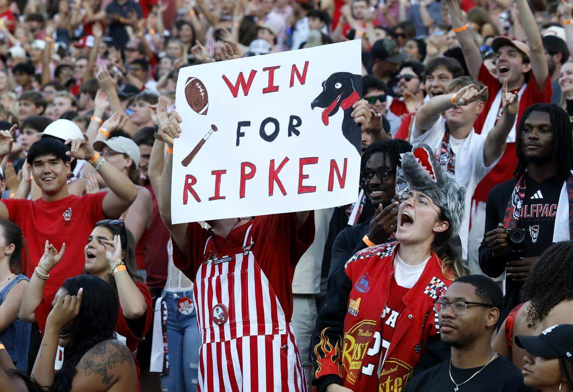 Fans cheer on the Wolfpack and Ripken before N.C. State’s game against ECU at Carter-Finley Stadium in Raleigh, N.C., Thursday, August 28, 2025. Ripken the Bat Dog used to retrieve the kicking tee for the football team and passed away on Jan. 1. Champ, Ripken’s brother, took over his duties this season.
