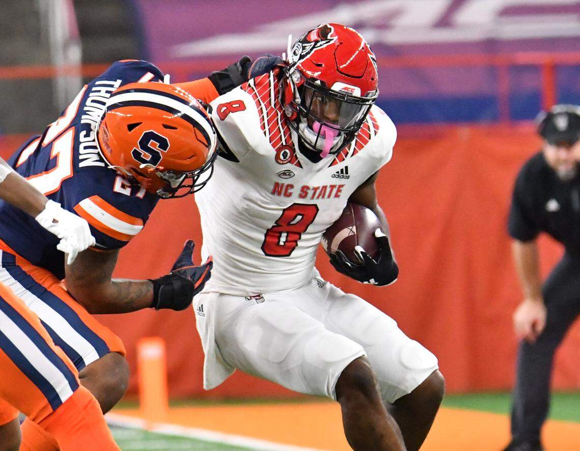 North Carolina State Wolfpack running back Ricky Person Jr. (8) is tackled by Syracuse Orange linebacker Stefon Thompson (27) in the first quarter at the Carrier Dome.