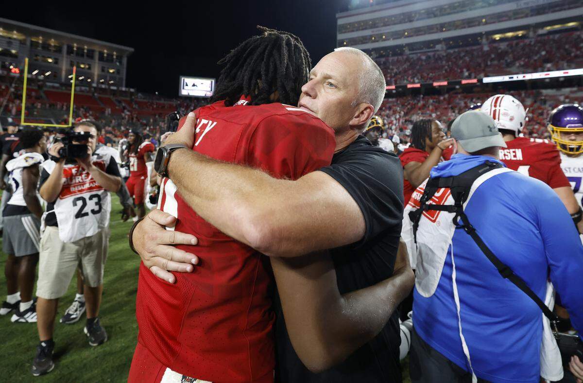 N.C. State head coach Dave Doeren hugs quarterback CJ Bailey (11) after N.C. State’s 24-17 victory over ECU at Carter-Finley Stadium in Raleigh, N.C., Thursday, August 28, 2025.