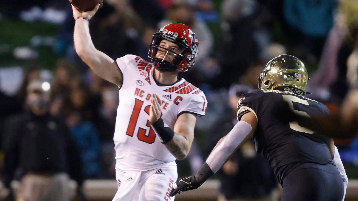 N.C. State quarterback Devin Leary (13) passes as Wake Forest linebacker Ryan Smenda Jr. (5) pressures him during the first half of N.C. States game against Wake Forest at Truist Field in Winston-Salem, N.C., Saturday, November 13, 2021.