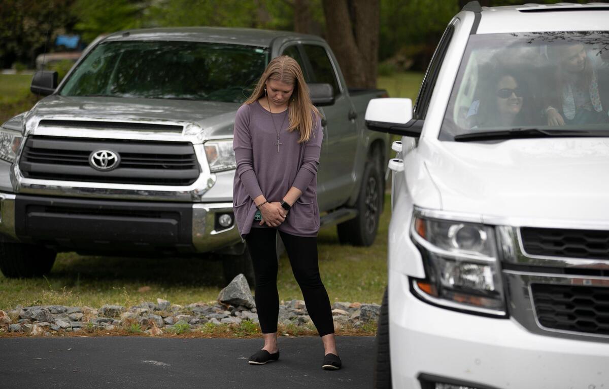 Samantha Barnes prays along with other worshipers, most of whom were in their cars, during Easter services at Micro First Baptist Church in Micro on Sunday. After several weeks of broadcasting their service via Facebook due to the COVID-19 virus, the church decided to hold a drive-in service in the church’s parking lot.