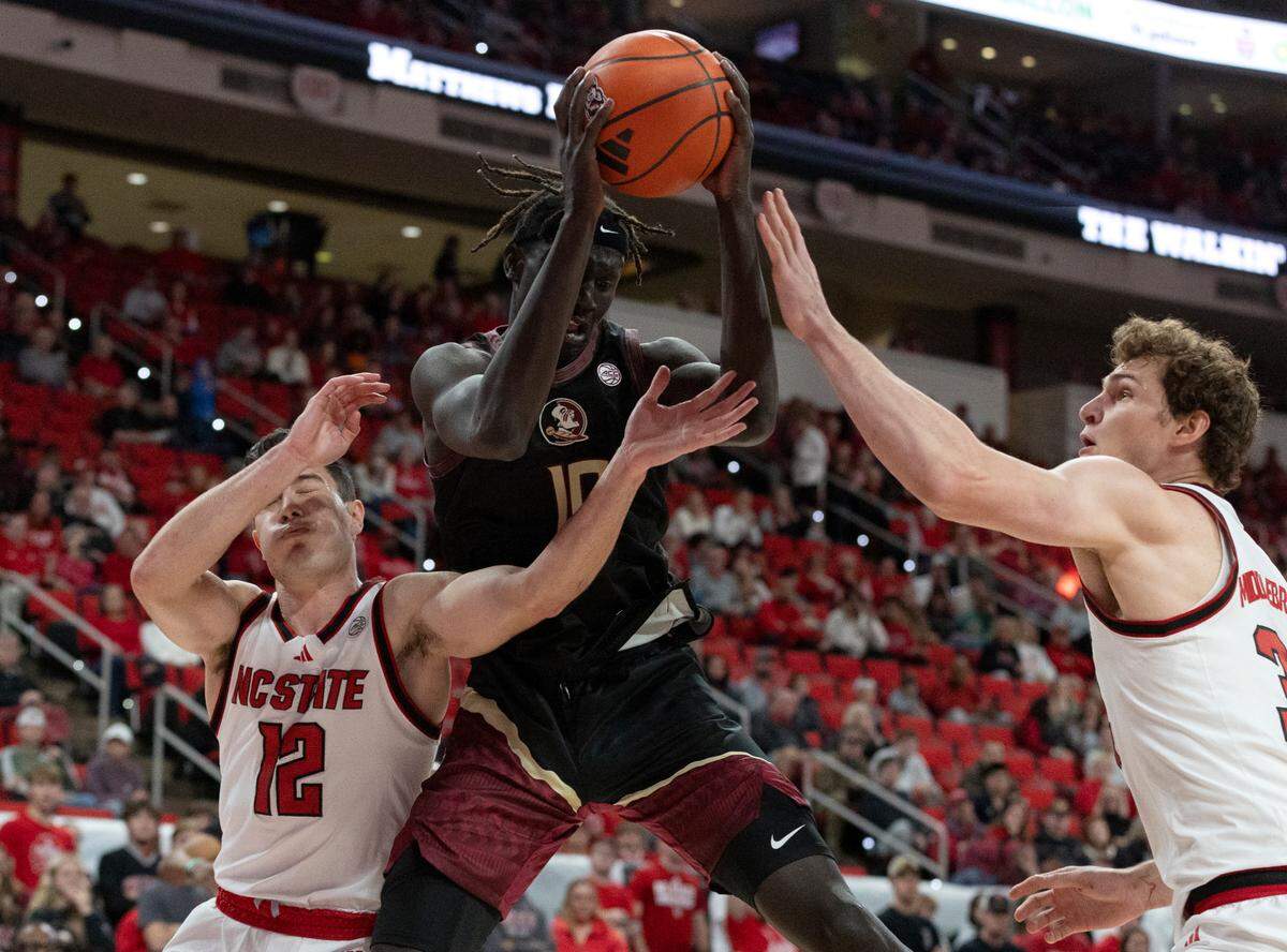 Florida State’s Taylor Bol Bowen pulls down a rebound away from N.C. State’s Michael O’Connell and Ben Middlebrooks during the first half of the Wolfpack’s 84-74 overtime win on Saturday, Dec. 7, 2024, at Lenovo Center in Raleigh, N.C.
