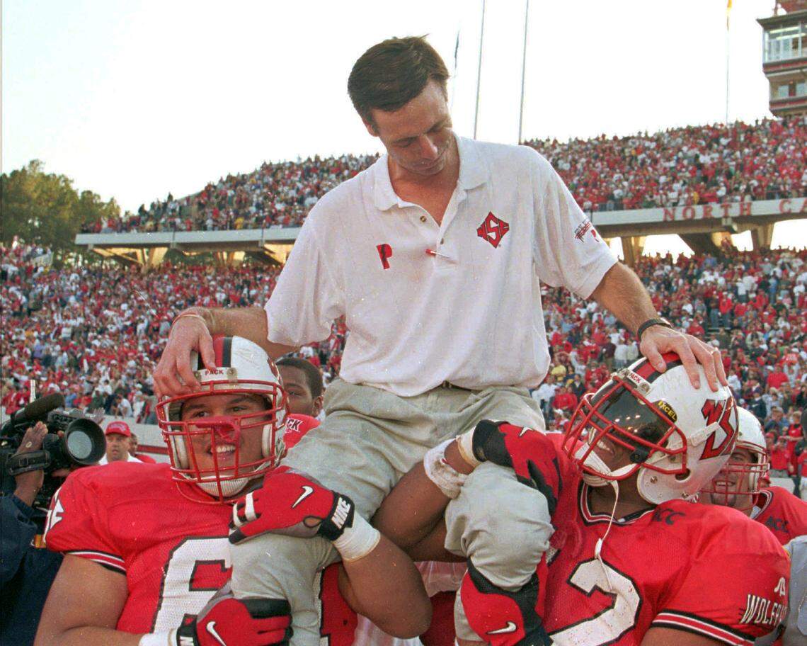 N.C.State head coach Mike O’Cain is carried off the field, after the Wolfpack’s 37-24 over ECU in 1997.