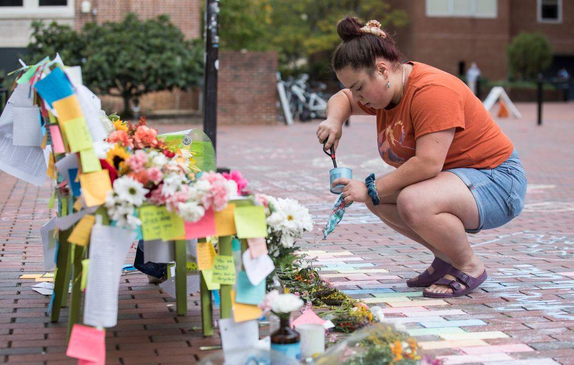 UNC-Chapel Hill senior Christie Scialabba lights a candle at a memorial for students reportedly lost to suicide in Chapel Hill, N.C. on Oct. 12, 2021.