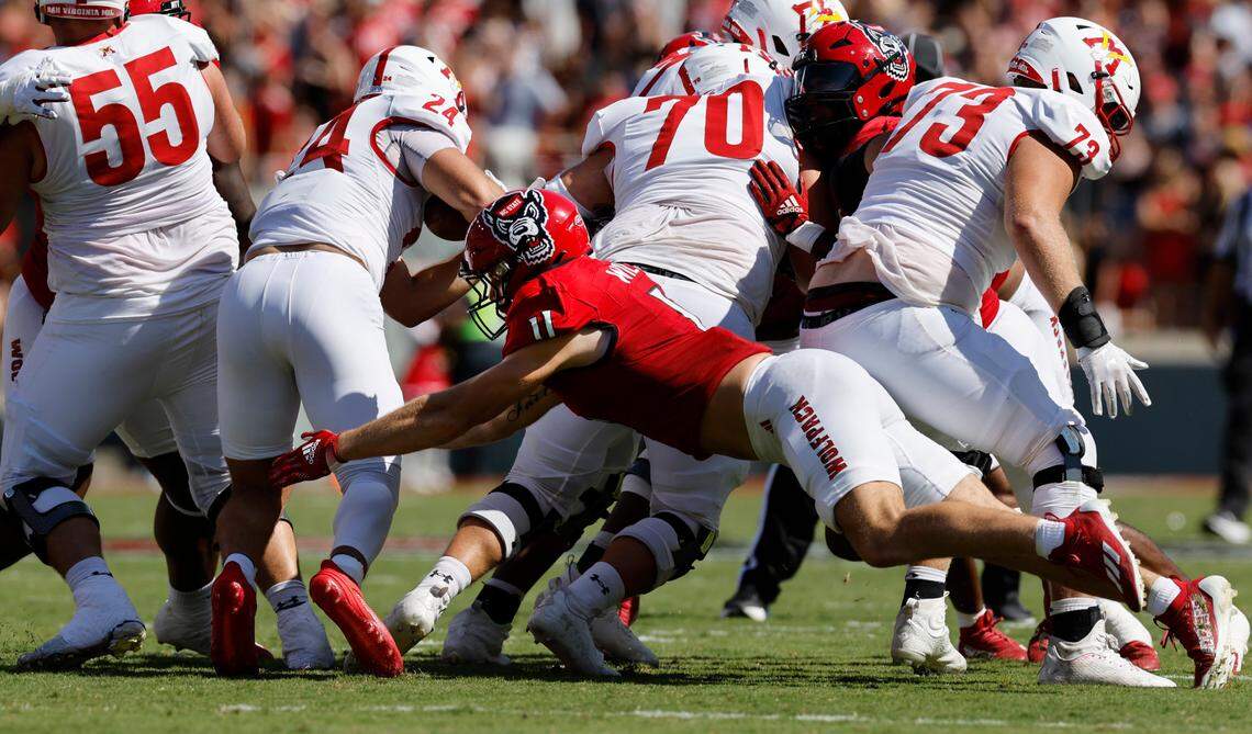 N.C. State linebacker Payton Wilson (11) dives to tackle Virginia Military Institute running back Hunter Rice (24) during the first half of N.C. State’s game against VMI at Carter-Finley Stadium in Raleigh, N.C., Saturday, Sept. 16, 2023.