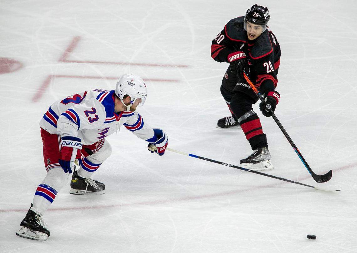 Carolina Hurricanes Sebastian Aho (20) passes around New York Rangers Adam Fox (23) in the first period on Friday, May 20, 2022 during game two of the Stanley Cup second round at PNC Arena in Raleigh, N.C.