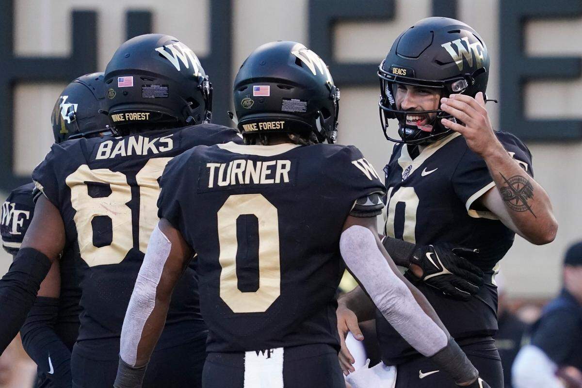 Wake Forest quarterback Sam Hartman (10) celebrates his touchdown run against Boston College with teammates Christian Turner (0) and Jahmal Banks (80) during the second half of an NCAA college football game in Winston-Salem, N.C., Saturday, Oct. 22, 2022.