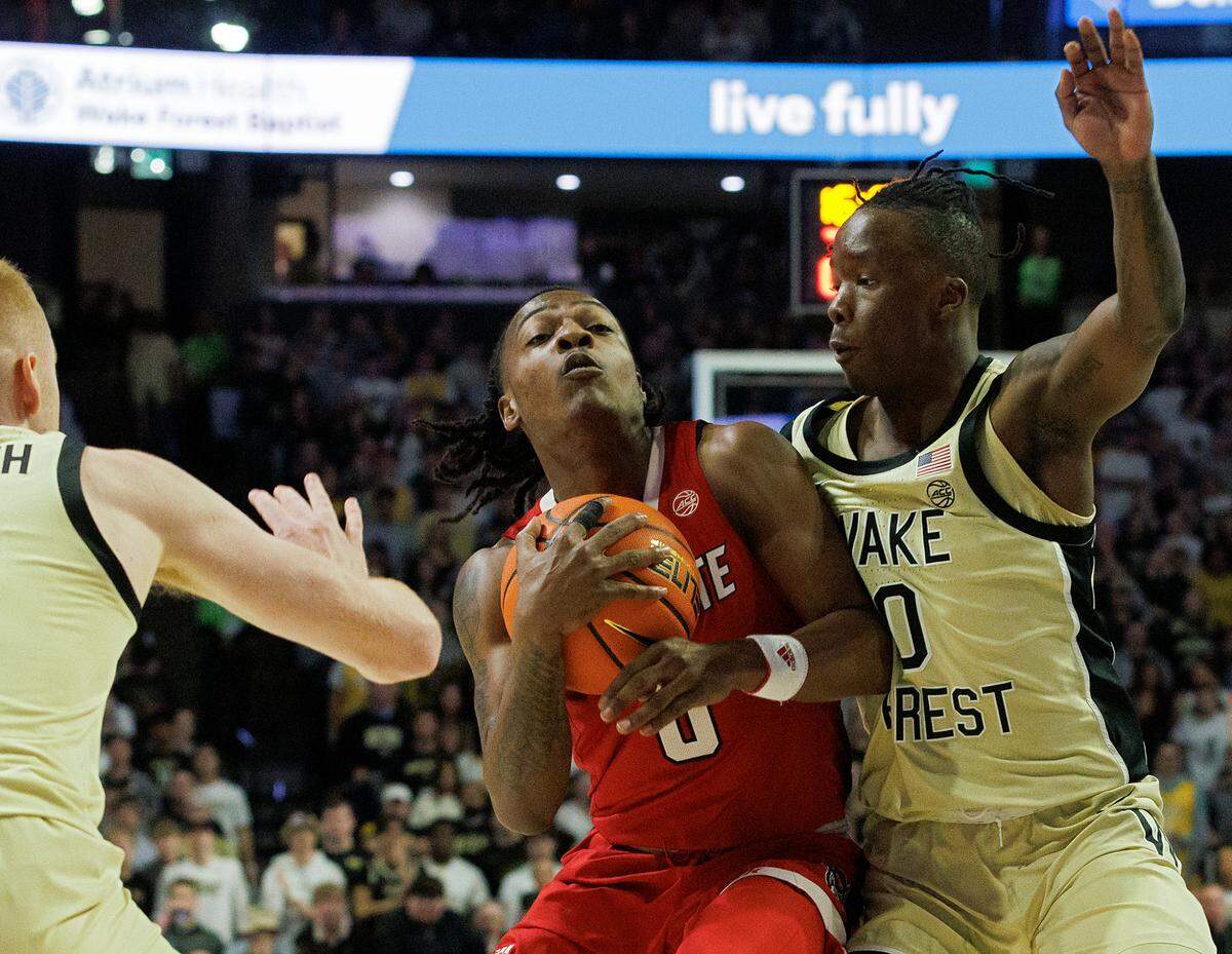 N.C. State’s DJ Horne drives between Wake Forest’s Cameron Hildreth and Kevin Miller during the first half of the Wolfpack’s game on Saturday, Feb. 10, 2024, at Lawrence Joel Veterans Memorial Coliseum in Winston-Salem, N.C.
