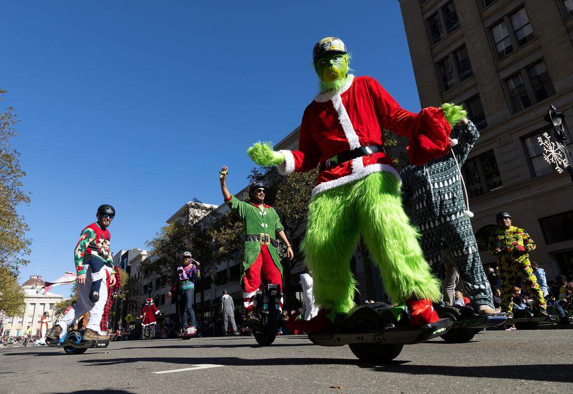 People in costume entertain the crowd on Fayetteville Street during the Raleigh Christmas Parade on Saturday, Nov. 18, 2023.