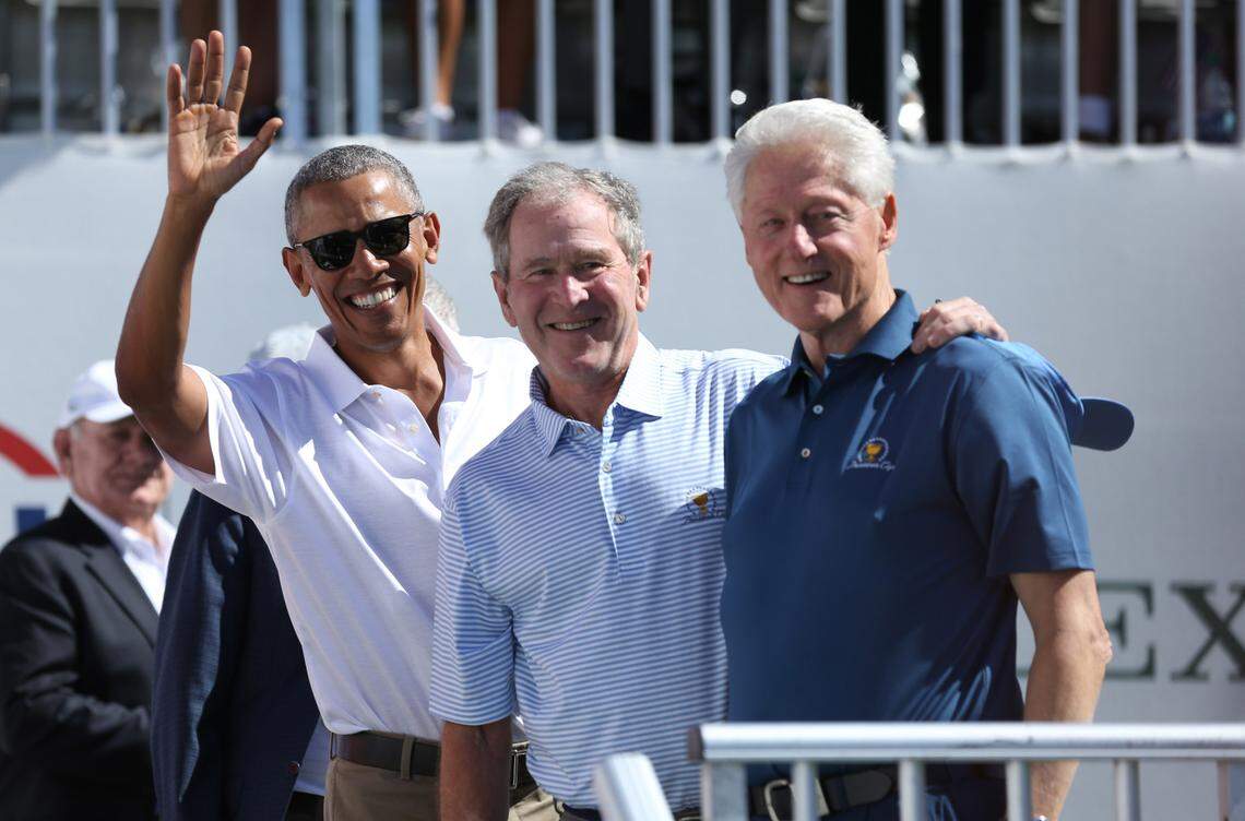 Former U.S. Presidents Barack Obama and George W. Bush and Bill Clinton smile during the first round foursomes match of The President’s Cup golf tournament at Liberty National Golf Course.