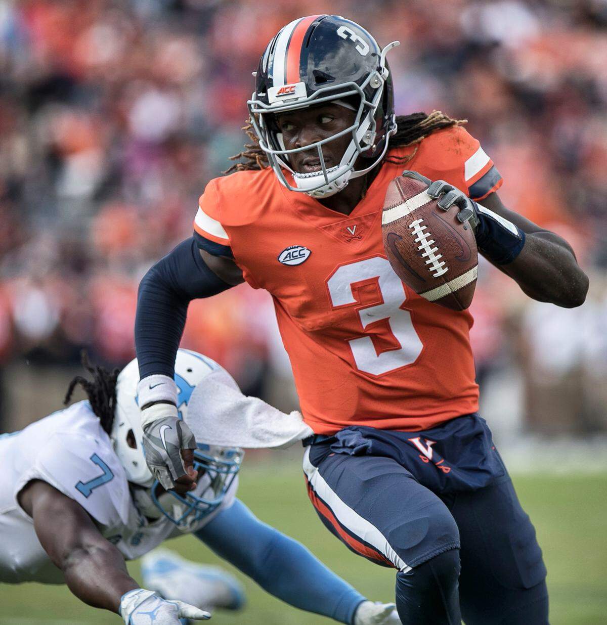 Virginia quarterback Bryce Perkins (3) scores on a 10 yard run ahead of North Carolina’s Jonathan Smith (7) to give Virginia a 7-0 lead in the first quarter on Saturday, October 27, 2018 at Scott Stadium in Charlottesville, Va. Perkins lead Virginia with 131 yards rushing and 217 yard passing in their 31-21 victory.
