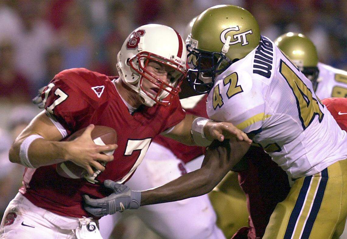 NC State quarterback Philip Rivers tries to escape from the grasp of Georgia Tech linebacker Recardo Wembush (42) during a game in 2000.