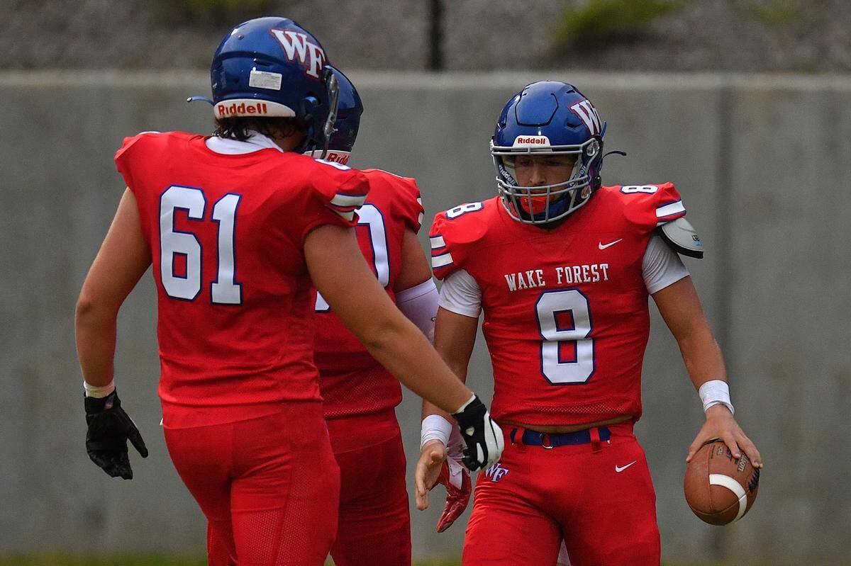 Wake Forest’s Brady Cole (61) celebrates with Michael Dipasquale (8) after his touchdown during the first half. The Wake Forest Cougars and the Southern Durham Spartans met in a football game in Wake Forest, N.C. on August 19, 2022.