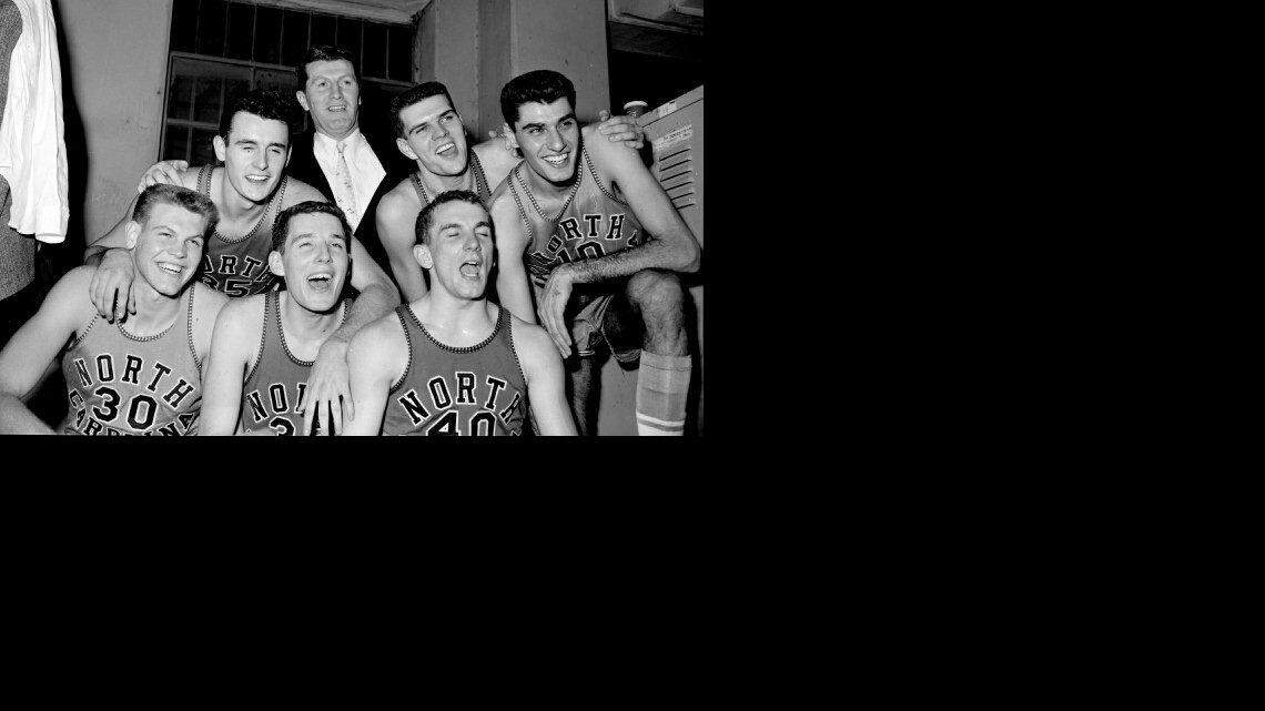 The 1957 Tar Heels pose with coach Frank McGuire in the UNC locker room at the ACC Tournament. Lennie Rosenbluth is at far right.