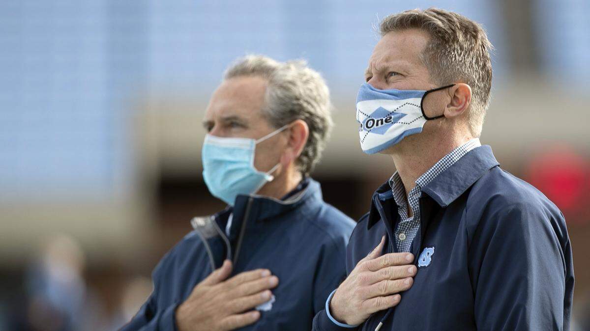North Carolina chancellor Kevin Guskiewicz and athletic director Bubba Cunningham stand for the National Anthem prior to the Tar Heels’ game against Western Carolina on Saturday, December 5, 2020 at Kenan Stadium in Chapel Hill, N.C.