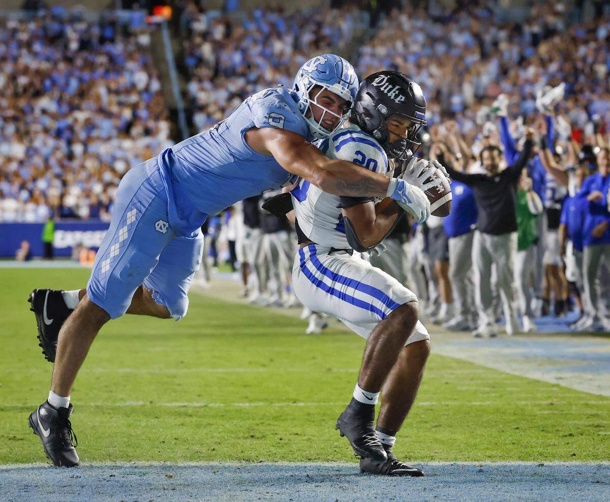 Duke’s Nate Sheppard scores a touchdown ahead of North Carolina’s Melkart Abou Jaoude during the second half of the Blue Devils’ 32-25 victory on Saturday, Nov. 22, 2025, at Kenan Stadium in Chapel Hill, N.C.