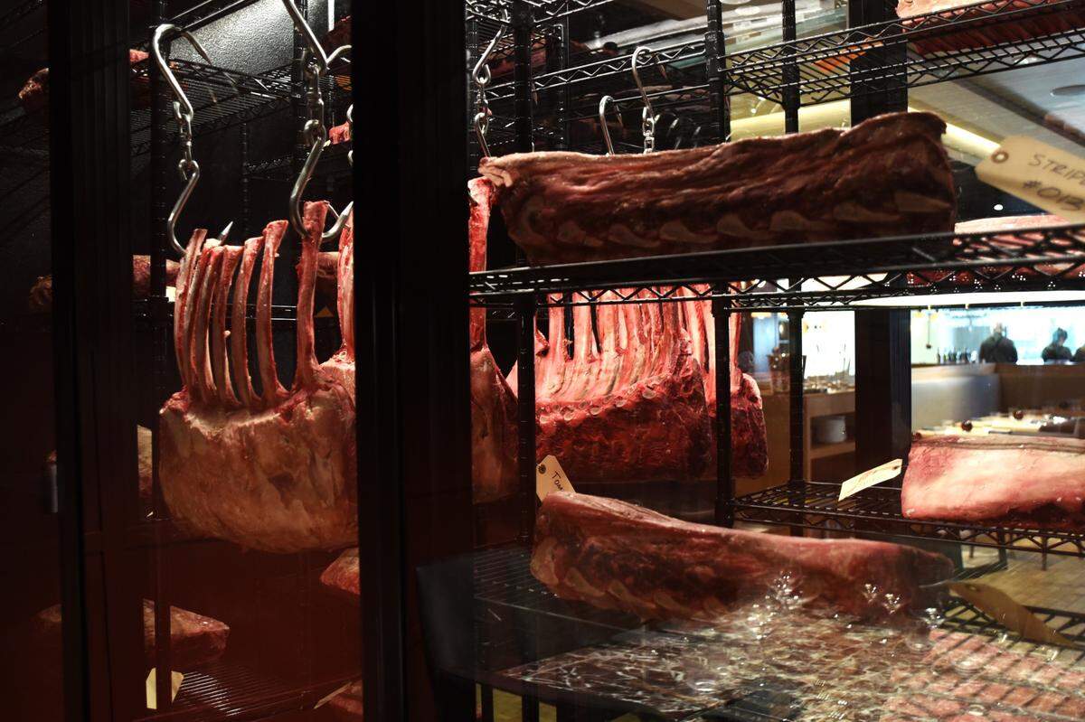 The meat locker at Crawford Brothers Steakhouse prominently displays some of the restaurant’s beef offerings, including giant tomahawk ribeyes and its dry-aging program.