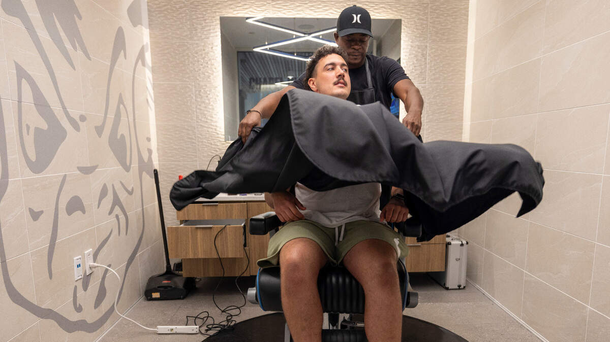 Barber Lionel Poteat drapes North Carolina punter Tom Maginess as he arrives for a haircut on Tuesday, September 10, 2024 at Kenan Stadium in Chapel Hill, N.C.