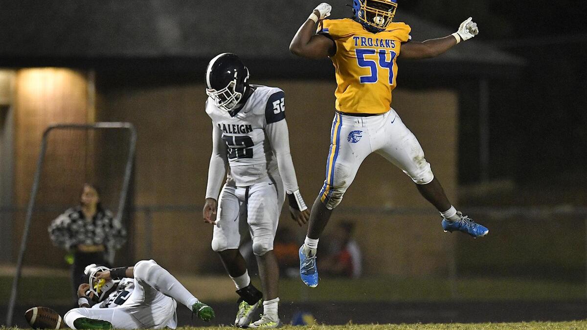 Garner’s Theo Butler (54) reacts after sacking Southeast Raleigh quarterback Tydreke Powell, Jr. (6) late in the fourth quarter. The Garner Trojans and the Southeast Raleigh Bulldogs met in a conference football game in Garner, N.C, on October 6, 2023