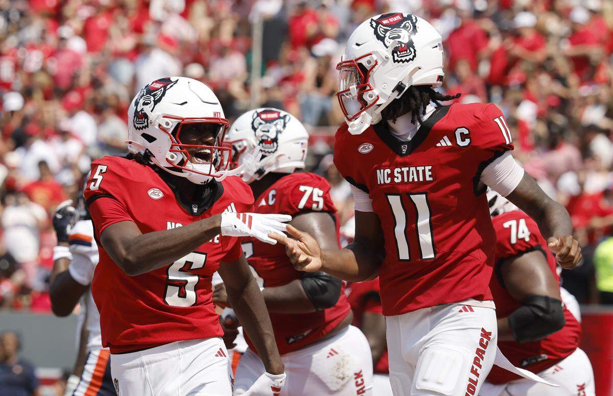 N.C. State wide receiver Noah Rogers (5) celebrates with quarterback CJ Bailey (11) after Rogers scored on a 27-yard touchdown reception during the first half of N.C. State’s game against Virginia at Carter-Finley Stadium in Raleigh, N.C., Sat. Sept. 6, 2025.