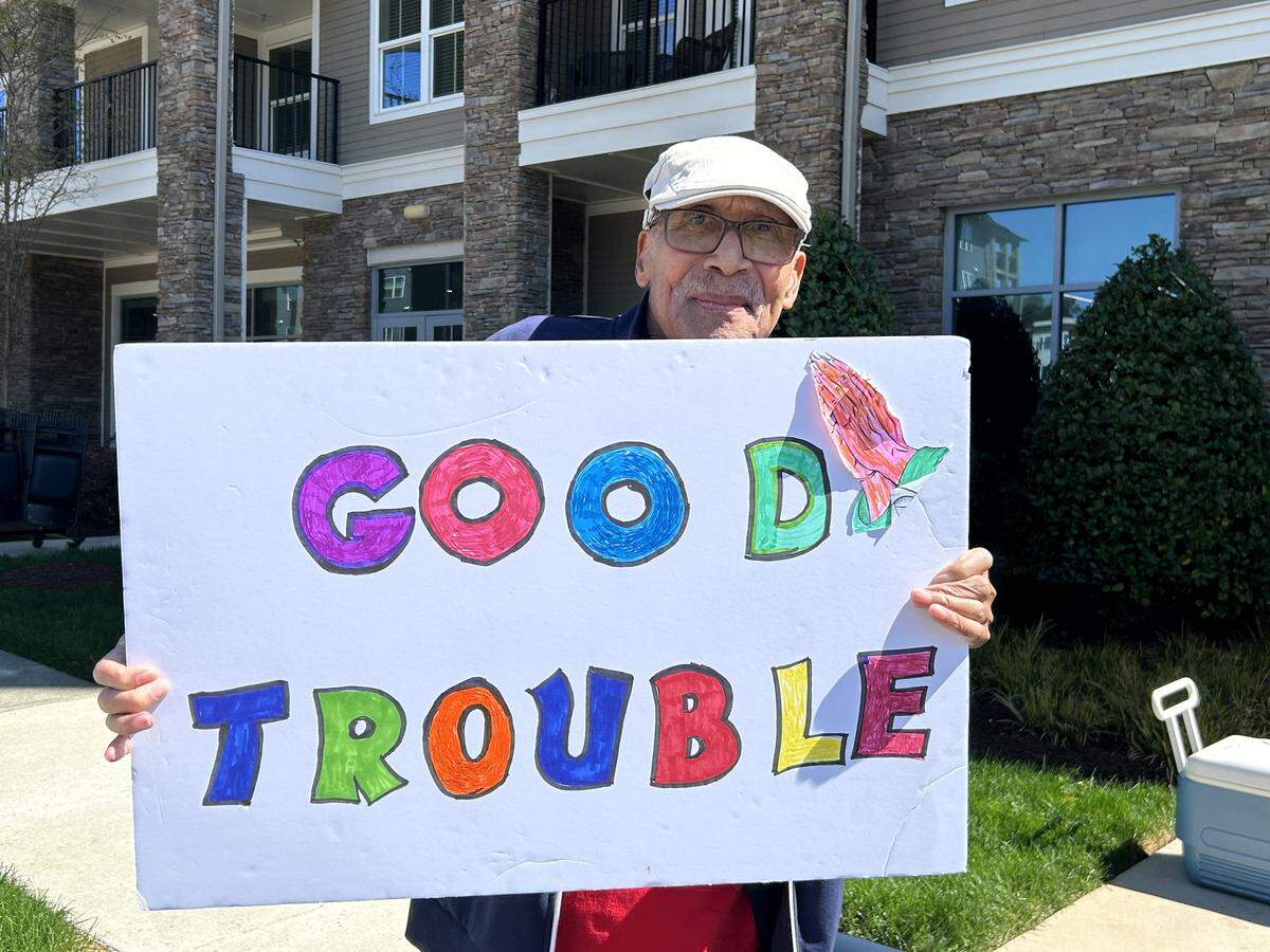 Hal Drane, a retired veteran, shows his discontent at a No Kings rally outside his senior citizen apartments Saturday in North Raleigh.