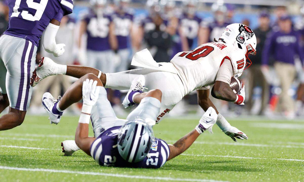 N.C. State wide receiver KC Concepcion (10) makes the reception while defended by Kansas State safety Marques Sigle (21) during the first half of N.C. State’s game against Kansas State in the Pop-Tarts Bowl at Camping World Stadium in Orlando, Fla., Thursday, Dec. 28, 2023.