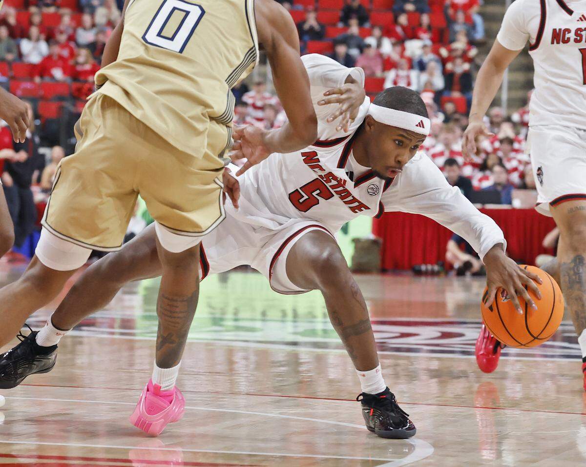 N.C. State’s Tre Holloman is pressured by Georgia Tech’s Akai Fleming during the second half of the Wolfpack’s 78-74 loss on Saturday, Jan. 17, 2026, at Lenovo Center in Raleigh, N.C. 