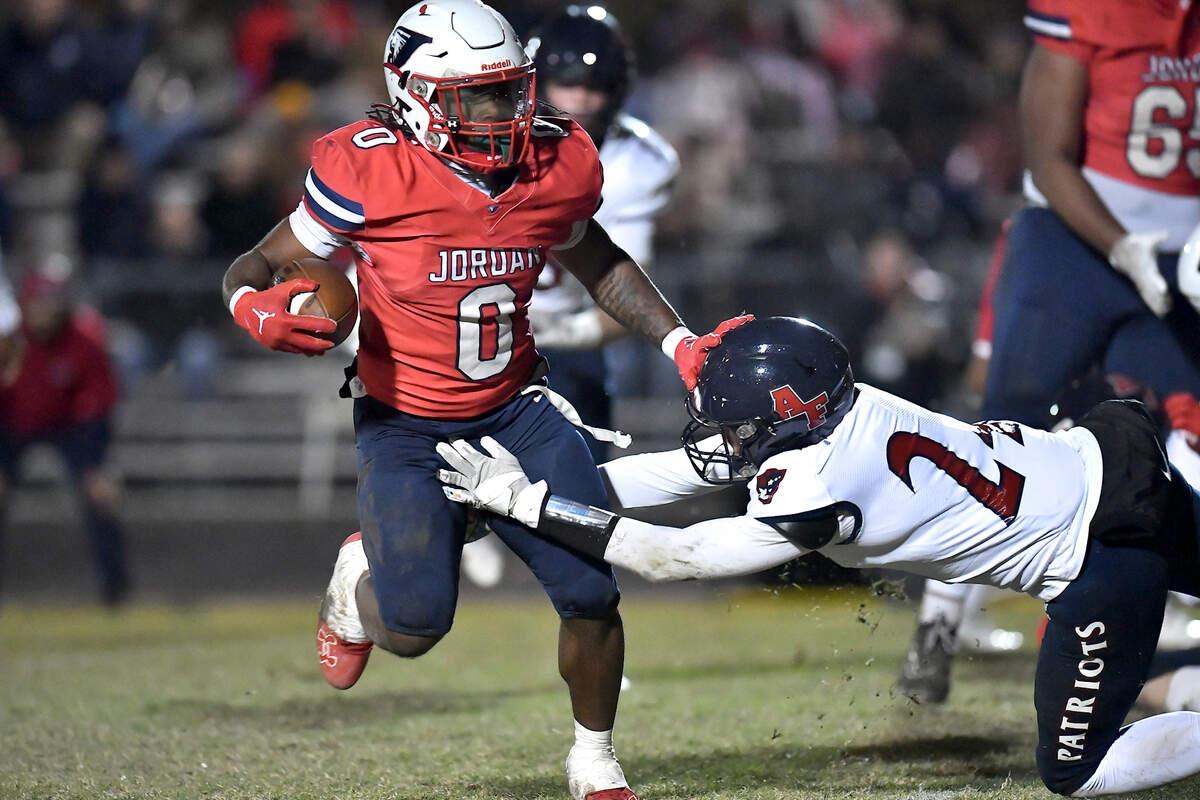 Jordan’s Amareon Blue (0) runs for yardage against Apex Friendship’s Logan Faulring (24) during the second half. The Apex Friendship Patriots and the Durham Jordan Falcons met in the second round of the NCHSAA 4A playoffs in Durham, N.C. on November 22, 2024.