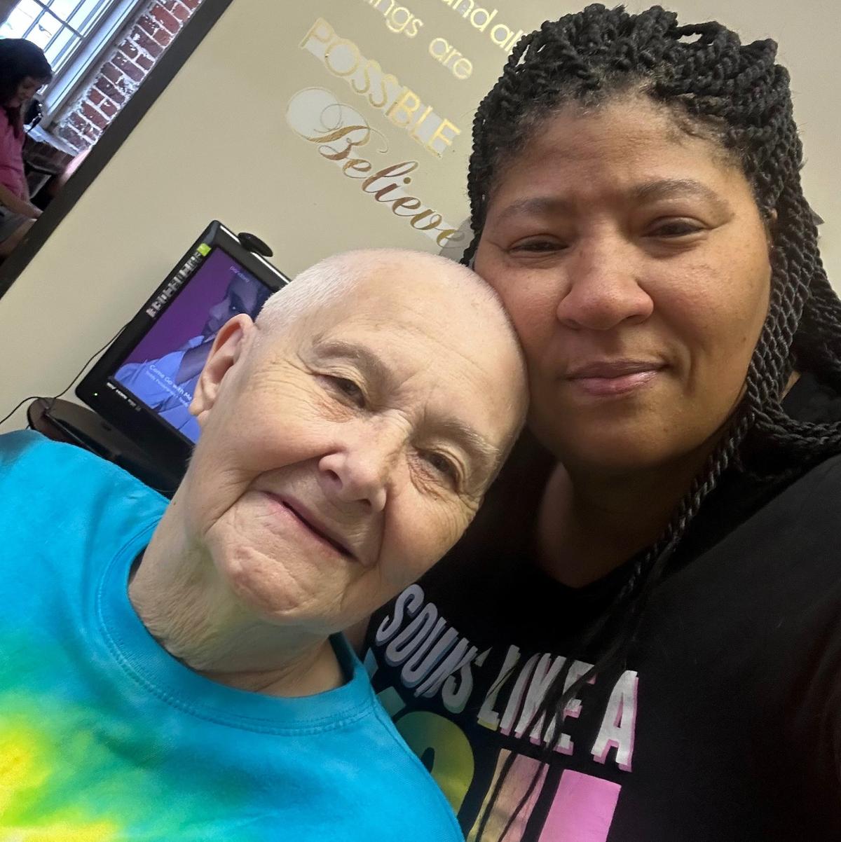 Deanna Bass (right), owner of Kutz Unlimited, poses with a client who was getting her head shaved while battling cancer. Bass is planning how to rebuild her longtime hair salon after a flood at the Eno River Mill in Hillsborough on July 6, 2025.