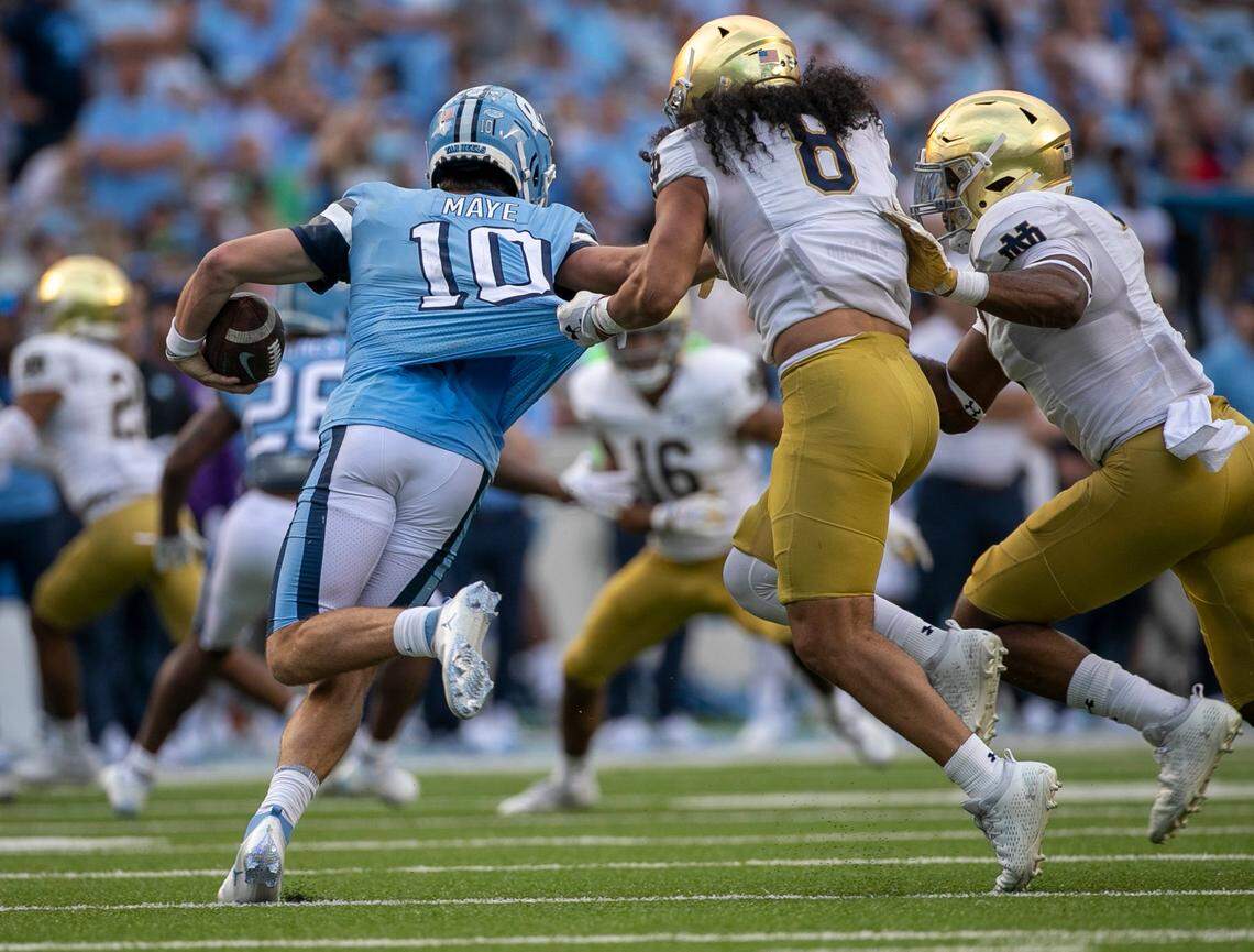 Notre Dame’s Isaiah Foskey (7) and Marist Liufau (8) work to sack North Carolina quarterback Drake Maye (10) for a five-yard loss in the third quarter on Saturday, September 24, 2022 at Kenan Stadium in Chapel Hill, N.C.