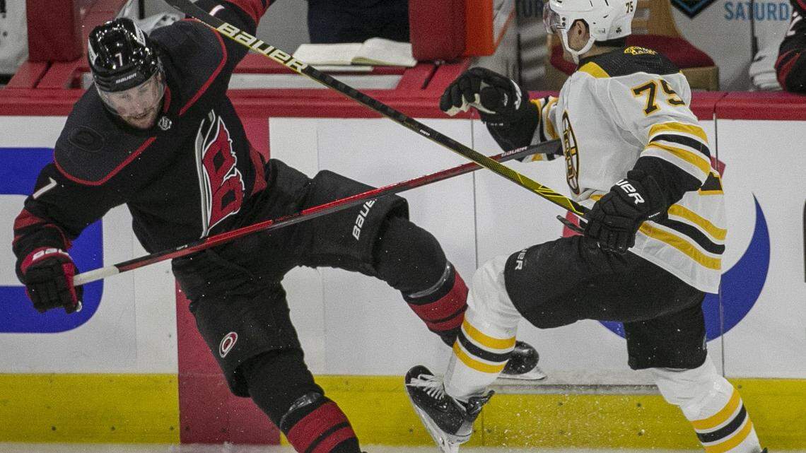 Boston Bruins Connor Clifton (75) checks Carolina Hurricanes Brendan Smith (7) in the second period on Wednesday, May 4, 2022 during game two of their Stanley Cup first round series at PNC Arena in Raleigh, N.C.