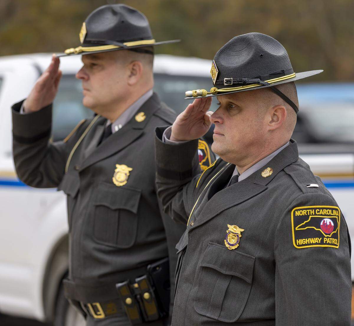 Two North Carolina state troopers salute, as the hearse bearing the casket of former North Carolina Gov. Jim Hunt departs First Presbyterian Church, en route to a private burial on Dec. 26, 2025, in Wilson.