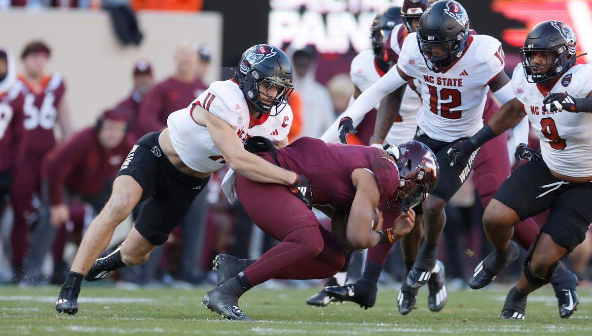 N.C. State linebacker Payton Wilson (11) stops Virginia Tech quarterback Kyron Drones (1) during the first half of N.C. State’s game against Virginia Tech at Lane Stadium in Blacksburg, VA, Saturday, Nov. 18, 2023.
