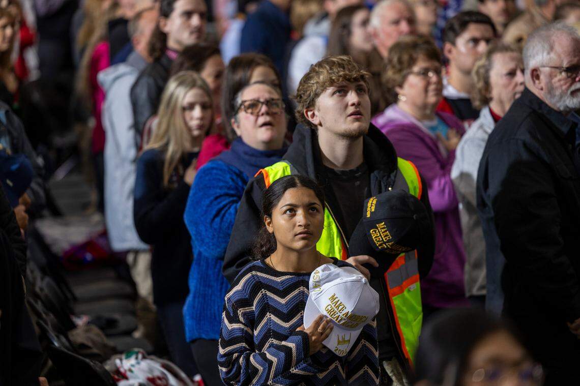 Supporters of Republican presidential nominee and former President Donald Trump stand during the National Anthem during a campaign rally at Dorton Arena in Raleigh on Monday, Nov. 4, 2024, one day before Election Day.