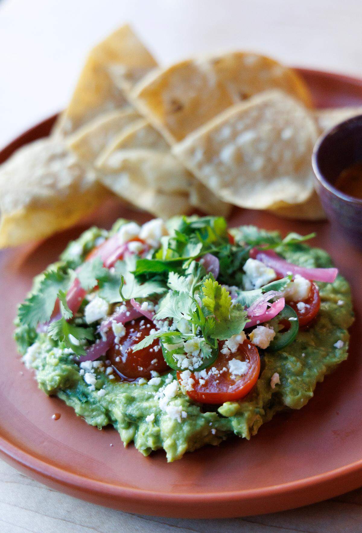 A plate of guacamole and white corn chips is pictured during a soft opening of Mala Pata on Tuesday, May 6, 2025, in Raleigh, N.C. The restaurant plans to open on May 14 at Raleigh’s Gateway Plaza.