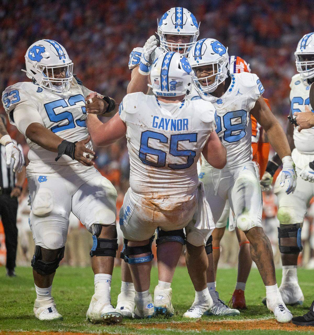 North Carolina’s Omarion Hampton (28) and Willie Lampkin (53) help Corey Gaynor (65) to his feet after Hampton scored a touchdown on a three-yard run in the fourth quarter against Clemson on Saturday, November 18, 2023 at Memorial Stadium in Clemson, S.C.