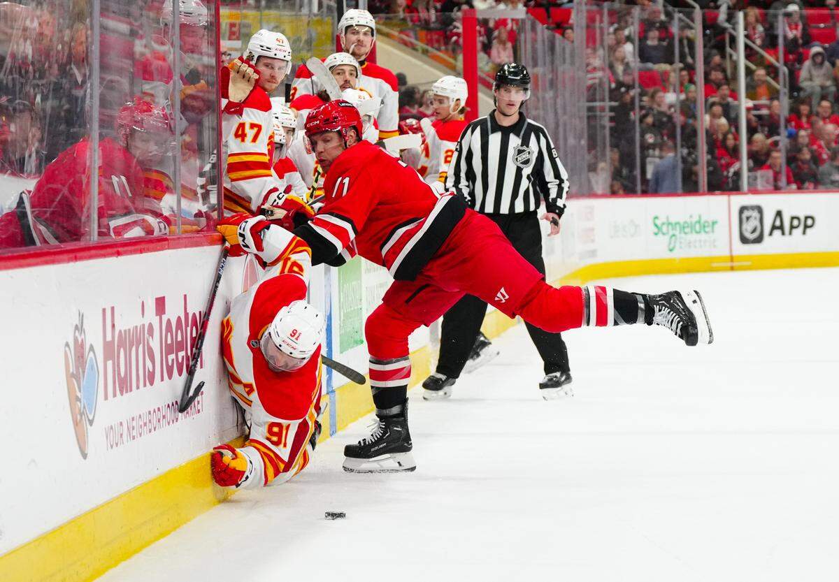 Carolina Hurricanes left wing Taylor Hall (71) checks Calgary Flames center Nazem Kadri (91) during the second period at Lenovo Center.