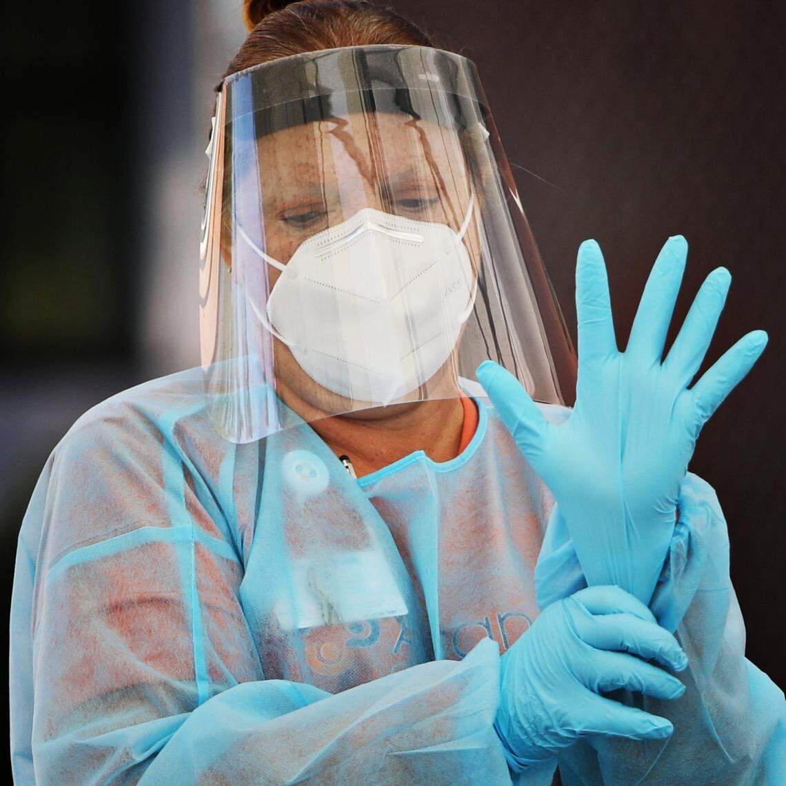 RN Tresa Webb puts on a fresh pair of gloves between clients at a COVID-19 testing drive-thru for Advance Community Health in Raleigh on Thursday, Nov. 5, 2020. Advance Community Health hosts several free testing sites each week.