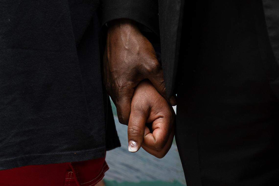Henrietta Mason, mother of Tyrone Mason who was killed in a car crash in October 2024, holds the hand of attorney Ben Crump during a rally outside the Wake County Courthouse in Raleigh, N.C. on Thursday, May 29, 2025.