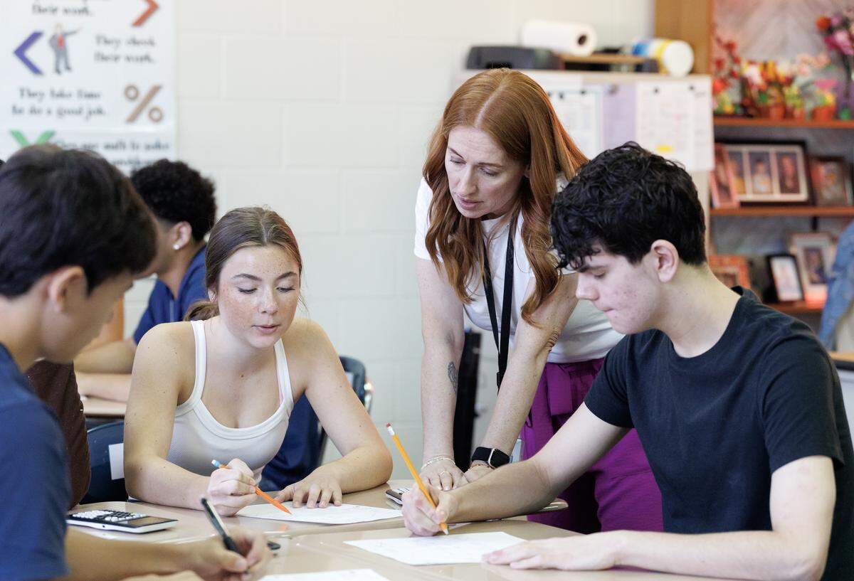 Math teacher Rachel Skipper helps sophomore Lily Hoffman, center, during a class at Millbrook High School on Tuesday, Sept. 2, 2025, in Raleigh, N.C.